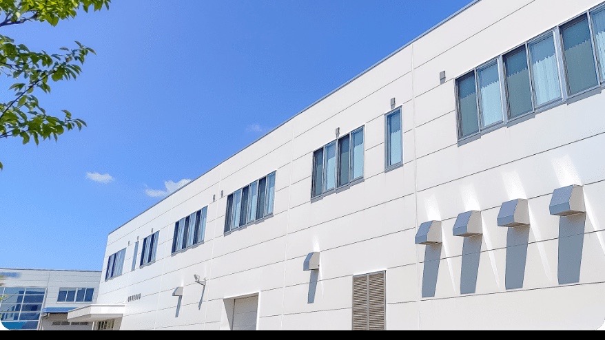 青空の下に建つ監修企業の建物